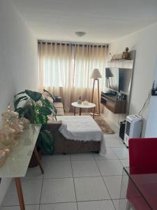 Apartamento Mobiliado para seu conforto في كاروارو: غرفة نوم بسرير وطاولة وتلفزيون