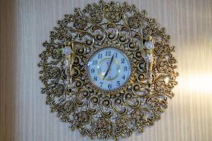 a gold clock hanging on a wall at Hotel Diamond Kazbegi in Stepantsminda