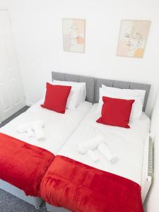 2 camas con almohadas rojas en una habitación en L.F.C Townhouse in Anfield, en Liverpool