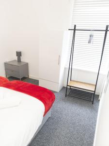 a bedroom with a bed and a chair next to a window at L.F.C Townhouse in Anfield in Liverpool