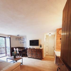 a living room with a television and a table at La Casa di Olivia - direttamente sulle piste (ski-in / ski-out) in La Thuile