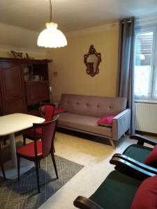 salon z kanapą i stołem w obiekcie Appart du 119 w mieście Sainte-Croix-aux-Mines