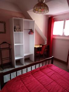 um quarto com uma cama com um cobertor vermelho em Appart du 119 em Sainte-Croix-aux-Mines