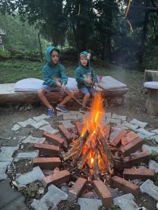 two children sitting next to a fire pit at Carpatic in Predeal