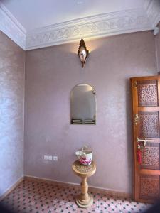a room with a table and a mirror on the wall at Dar Dikrayat in Marrakech