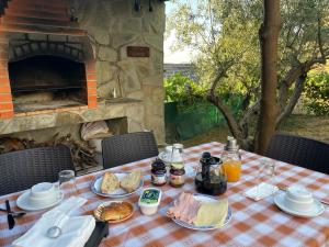 een picknicktafel met eten en een steenoven bij Casa da Caroline in Freixo de Espada à Cinta