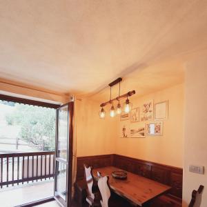 une salle à manger avec une table et un balcon dans l'établissement La Casa di Olivia - direttamente sulle piste (ski-in / ski-out), à La Thuile
