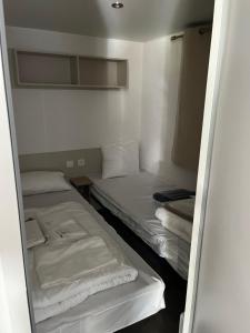 a small room with two beds in it at Location mobil home saison 2023 in Saint-Jean-de-Monts