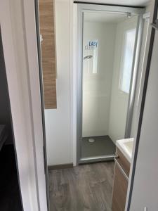 a bathroom with a walk in shower next to a mirror at Location mobil home saison 2023 in Saint-Jean-de-Monts