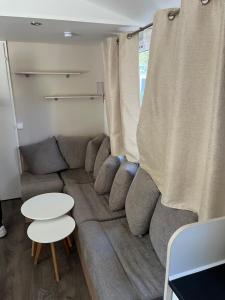 a living room with a couch and a table at Location mobil home saison 2023 in Saint-Jean-de-Monts