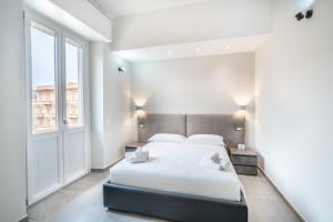 um quarto branco com uma cama e uma janela em Kuzu apts - City Center - WiFi AC TV em Cagliari