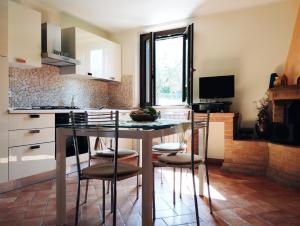 eine Küche mit einem Tisch mit Stühlen und einer Theke in der Unterkunft La Casa Tra Gli Ulivi in Cortona