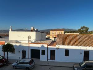 un edificio blanco con coches estacionados en un estacionamiento en Apartamento La Mesta, Facinas - Tarifa, en Facinas