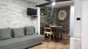 - un salon avec un canapé et une table avec un réveil dans l'établissement Casa La Rosa, à Coreglia Ligure