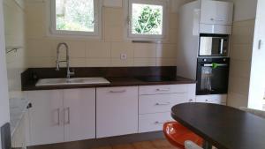 eine Küche mit weißen Schränken und einem Waschbecken in der Unterkunft Très jolie villa à Vence in Vence