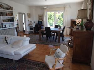 ein Wohnzimmer mit einem weißen Sofa und einem Tisch in der Unterkunft Très jolie villa à Vence in Vence