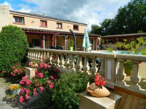 Casa con balcón con flores y plantas en Le Clos des Dryades s, en Vers