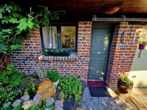 ein Backsteinhaus mit einer Tür und einigen Pflanzen in der Unterkunft Studio Malow in Arques