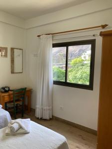 Schlafzimmer mit einem Fenster, einem Schreibtisch und einem Bett in der Unterkunft Casa Isidoro in Valle Gran Rey