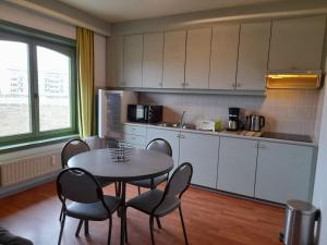 cocina con mesa y sillas en una habitación en APPARTEMENT WESTENDE (DRIEMASTER), en Middelkerke