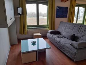 sala de estar con sofá y mesa de cristal en APPARTEMENT WESTENDE (DRIEMASTER), en Middelkerke