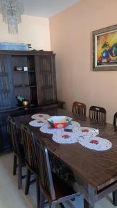 een houten tafel met stoelen en een kom erop bij Praia Grande Boqueirão e Guilhermina in Praia Grande