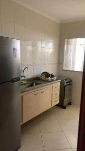 een keuken met een spoelbak en een koelkast bij Praia Grande Boqueirão e Guilhermina in Praia Grande