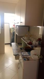 een keuken met een aanrecht met daarop servies bij Praia Grande Boqueirão e Guilhermina in Praia Grande +7 foto's