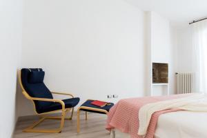 een slaapkamer met een blauwe stoel en een bed bij San Giovanni in San Gimignano