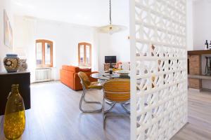 een woonkamer met een witte scheidingswand met een tafel en stoelen bij San Giovanni in San Gimignano
