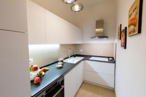 a kitchen with white cabinets and a bowl of fruit on the counter at San Giovanni Apartment in San Gimignano
