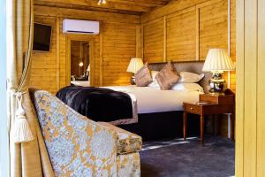 a bedroom with a bed and a table and a couch at The Inn On The Green in Cookham Dean