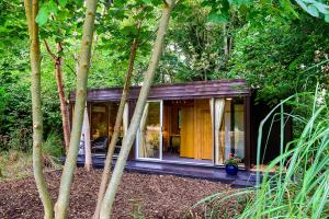 a small house in the middle of a forest at Sanctum On The Green Hotel in Cookham Dean