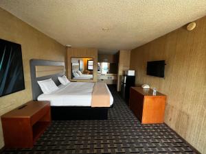 a hotel room with a bed and a television at Casa Playa Inn & Suites Stanton Anaheim Area in Stanton