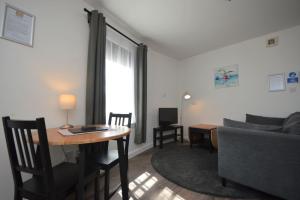 a living room with a table and a couch at Otter Apartment in Tobermory