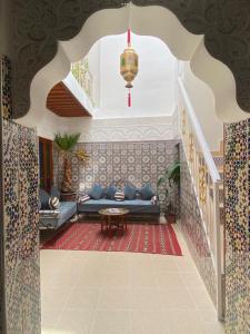 ein Wohnzimmer mit einem blauen Sofa und einer Treppe in der Unterkunft Dar Dikrayat in Marrakesch