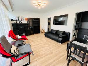 a living room with a black couch and chairs at Residential area - quiet place in Brussels