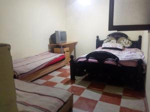 1 Schlafzimmer mit 2 Einzelbetten und einem TV in der Unterkunft Atlas TAHANAOUT in Tahannaout