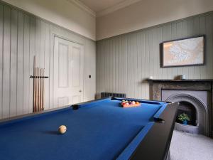 a blue pool table in a room with a fireplace at Bad Daraich in Tobermory