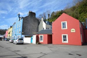 a red building with a bird on top of it at Dolphin Apartment in Tobermory