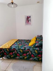 a bed with a colorful blanket on it in a room at Entre arènes et maison carrée P1 in Nîmes