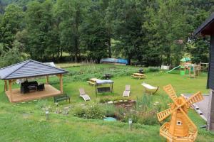 un giardino con gazebo e parco giochi di La Ferme de Rochesson, Jacuzzis & Piscine commune a Rochesson
