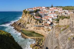 a village on a cliff next to the ocean at Azenhas do Mar Valley House in Sintra