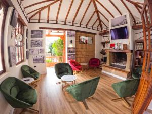 a living room with green chairs and a fireplace at Hotel Boutique El Carmel in Villa de Leyva