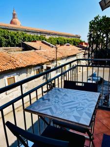 un tavolo e delle sedie sul balcone di un palazzo di Teatro Greco Suite a Catania