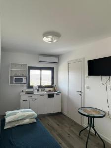 una pequeña cocina con mesa en una habitación en סטודיו חדש ויפה עם נוף לים, en Netanya