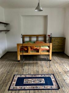 een slaapkamer met een bed en een tapijt op een houten vloer bij Rodinný domek v centru Plané nad Luž. Jižní Čechy in Planá nad Lužnicí