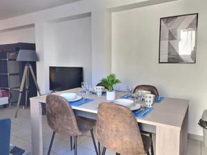 a dining room table with chairs and a table and a television at CHATENAY 2 in Fontenay-aux-Roses