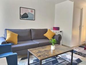 a living room with a couch and a coffee table at CHATENAY 2 in Fontenay-aux-Roses