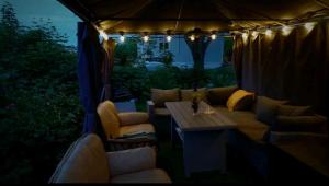 a patio with a couch and a table and lights at Nahlboms in Sandefjord